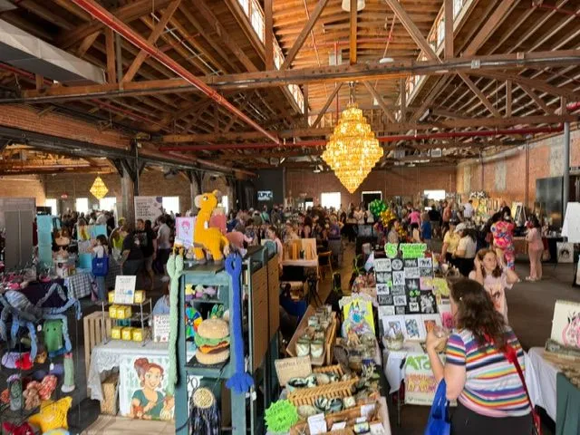 Shoppers browsing handmade goods and artist booths at the Queer Holiday Market